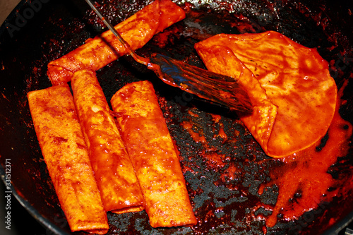 Enchiladas, platillo típico mexicano. Hecho con chiles guajillos y tortillas. Acompañado de cebolla, crema, queso, zanahorias, ppapas y lechuga photo