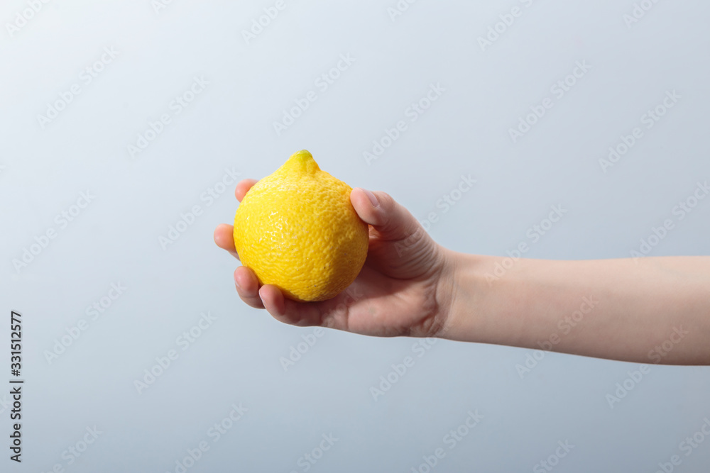 Hand holding isolated lemon in white background. Horizontal view. Hand holding isolated lemon in white background. Horizontal view.