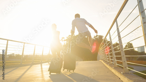 LENS FLARE: Man excited to go on trip jumps in air and pumps his fist at sunset
