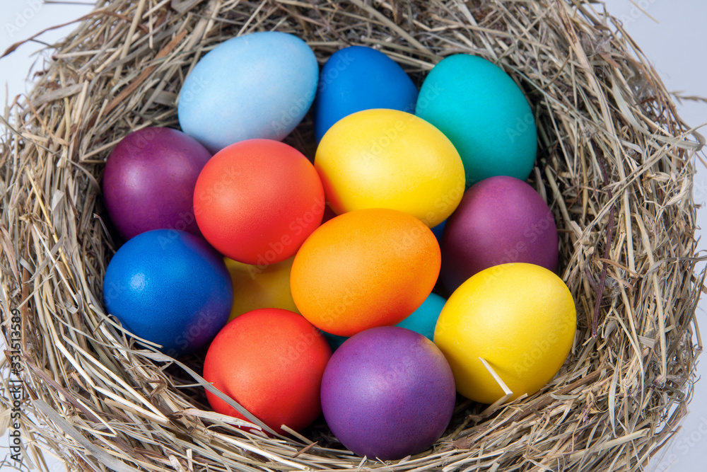 Multicolored eggs in nest in the hay. Concept easter.