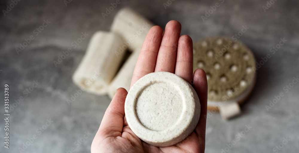 Fototapeta premium Eco friendly natural solid shampoo on grey background. Concept animal fat free, zero waste, plastic free product