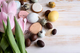 Beautiful Easter composition of eggs with natural colors, gingerbread, flowers, feathers.