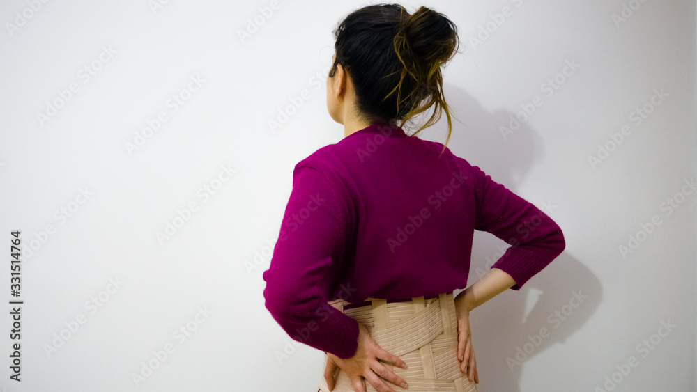 Woman suffering backache on the white background. Young woman with back pain. Lumbago. Back pain or backache concept. Woman with girdle or corset suffering backache or back pain. Copy space for text. Woman suffering backache on the white background. Young woman with back pain. Lumbago. Back pain or backache concept. Woman with girdle or corset suffering backache or back pain. Copy space for text.