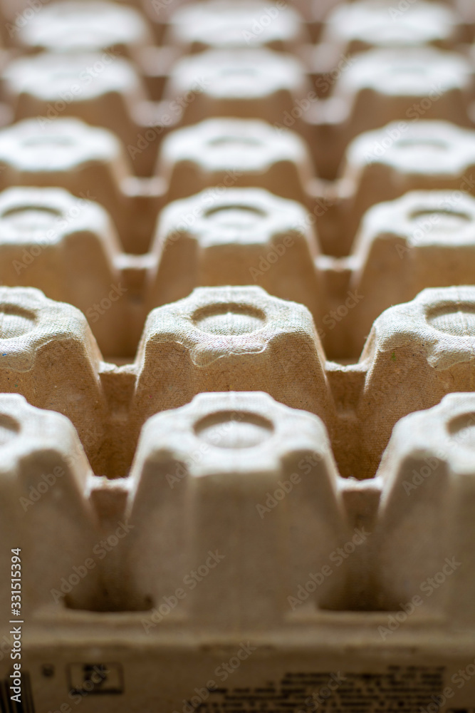 Obraz premium A lot of empty cardboard egg cartons in a row. Bottom of egg trays. Vertical