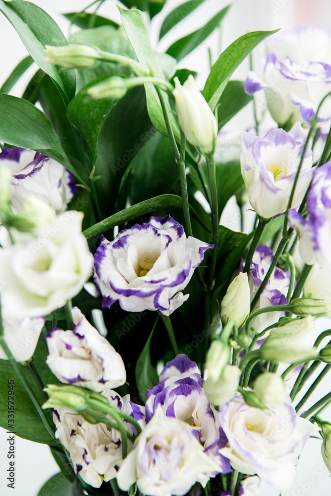 Beautiful bouquet of spring flowers in vase. Floral composition of fresh white violet eustoma flowers. Gift. Celebration concept. Blooming flowers. Beautiful bouquet of spring flowers in vase. Floral composition of fresh white violet eustoma flowers. Gift. Celebration concept. Blooming flowers.