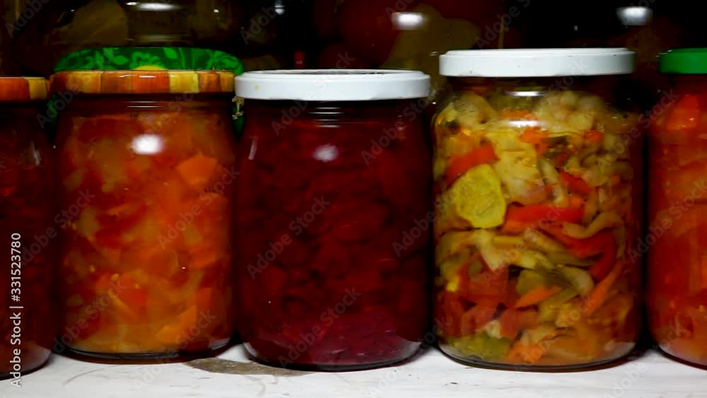 Glance slides along row of glass jars of pickled vegetables in pantry Glance slides along row of glass jars of pickled vegetables in pantry