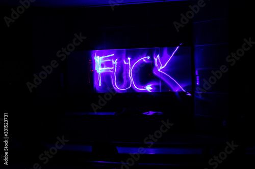 Pintando figuras con luz sobre un fondo blanco en un cuarto oscuro