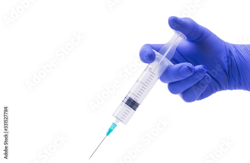 hand in a medical glove holds a syringe