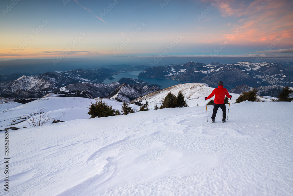 A man enjoys a winter trekking adventure in Lombardia, Italy.