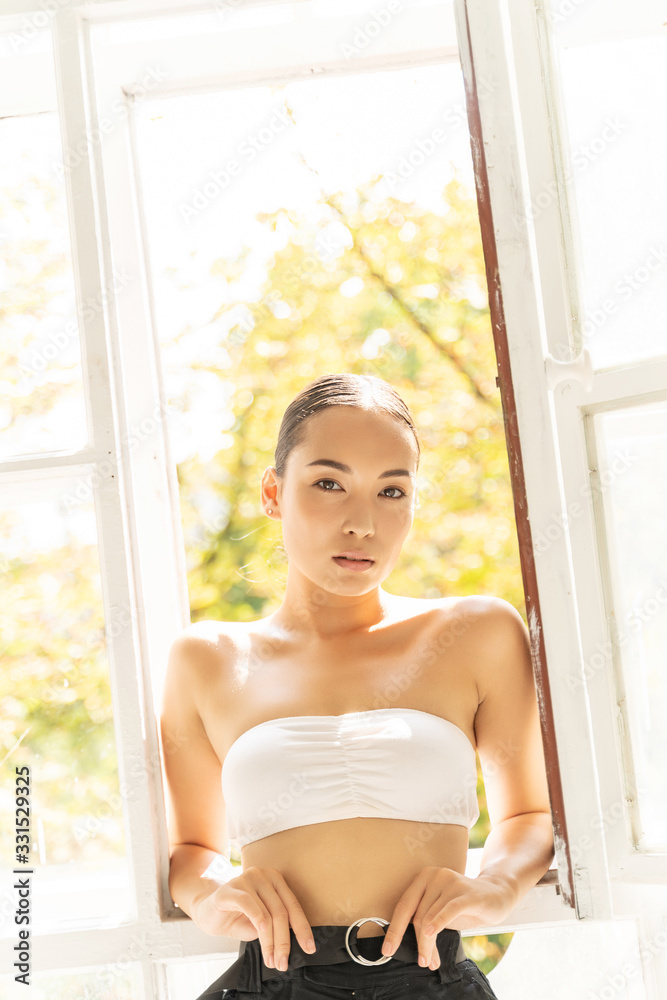 Calm Asian woman looking at camera indoors
