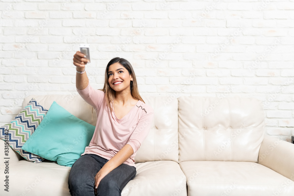 Smiling Woman Using Remote Control At Home Smiling Woman Using Remote Control At Home