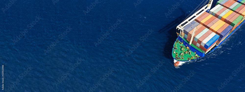 Aerial drone top down photo of fully loaded large truck size container tanker ship cruising the Mediterranean deep blue sea