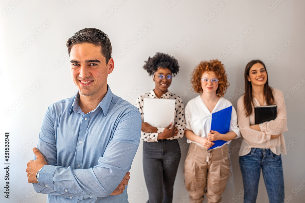 Fototapeta premium Portrait of a young designer standing in an office with his colleagues in the background. Cropped shot of a businessman standing in the office with his arms folded looking confident