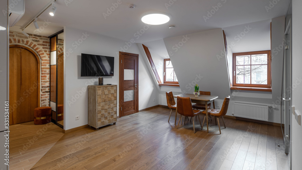 Fototapeta premium Modern contemporary interior of living room with furniture and tv. Sloping ceiling. Private house.
