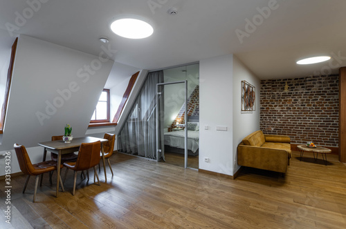 Modern contemporary interior of studio apartment. Private house. Brick wall. Glass wall. Bedroom.