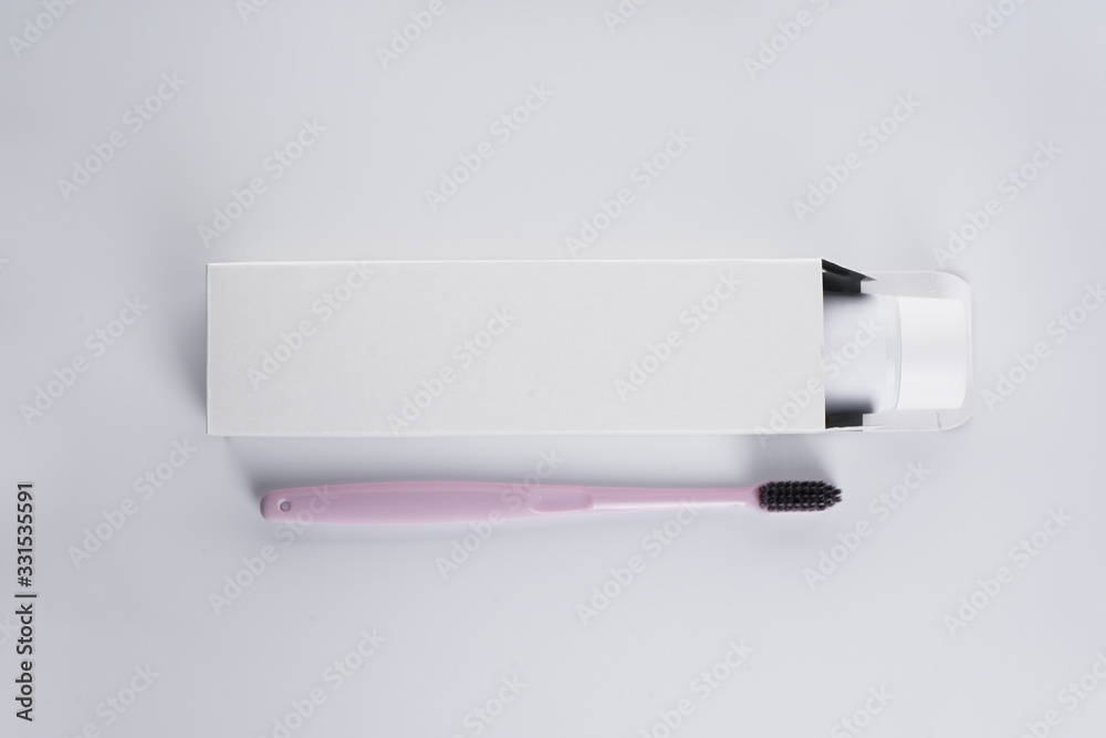 Flat lay composition of toothbrush and toothpaste on a white background