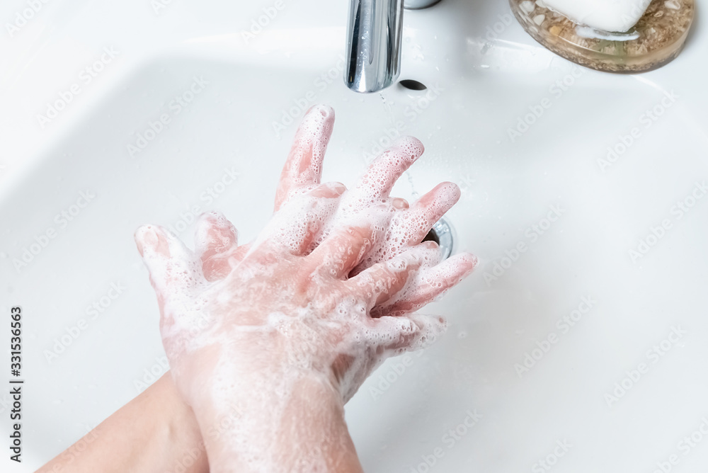 Washing hands with soap under the faucet with water Washing hands with soap under the faucet with water