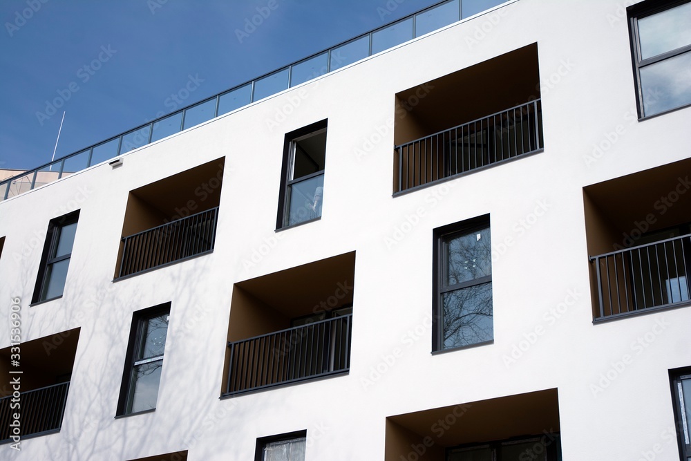 Exterior of new apartment buildings on a blue cloudy sky background. No people. Real estate business concept. Exterior of new apartment buildings on a blue cloudy sky background. No people. Real estate business concept.