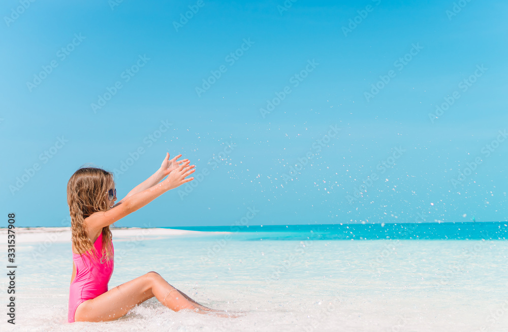 Adorable little girl have fun at tropical beach during vacation Adorable little girl have fun at tropical beach during vacation