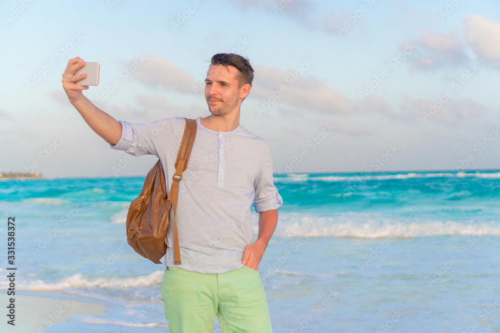 Young man taking selfie on the beach background the sea Young man taking selfie on the beach background the sea