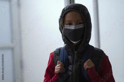 Niño con tapaboca y morral 