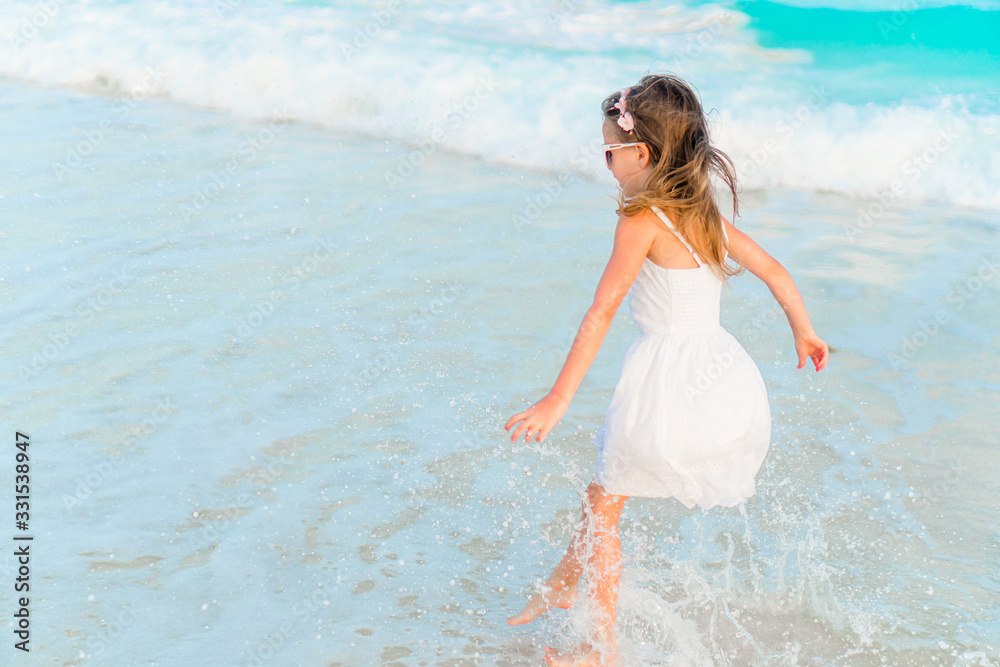 Adorable happy little girl have fun on beach vacation