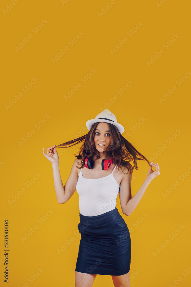 A European brunette, well disposed and with a smile, dressed sexy and with a hat on her head that listens to the music and is surprised. A European brunette, well disposed and with a smile, dressed sexy and with a hat on her head that listens to the music and is surprised.