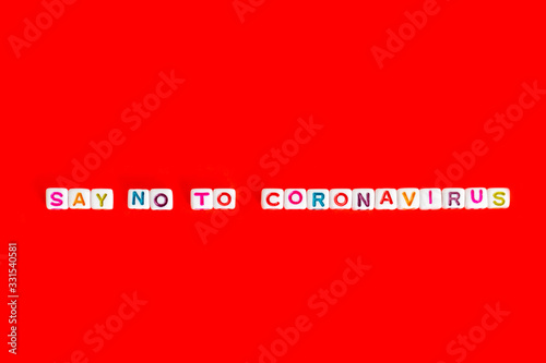 Phrase "say no to coronavirus" made out of colorful beads on red background