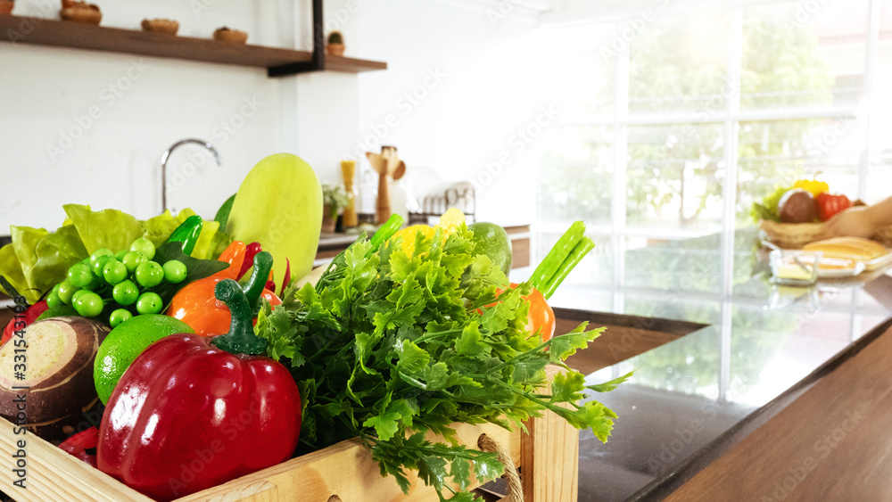 Organic vegetables and fruits in wooden basket box prepare for cooking fresh salad or delicious health food on black granite counter bar near window in kitchen studio room at house