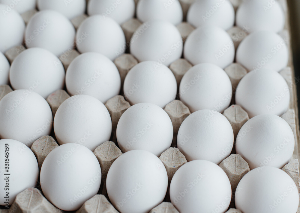 Tray of white fresh eggs close-up on a cardboard form. Agricultural industry Tray of white fresh eggs close-up on a cardboard form. Agricultural industry