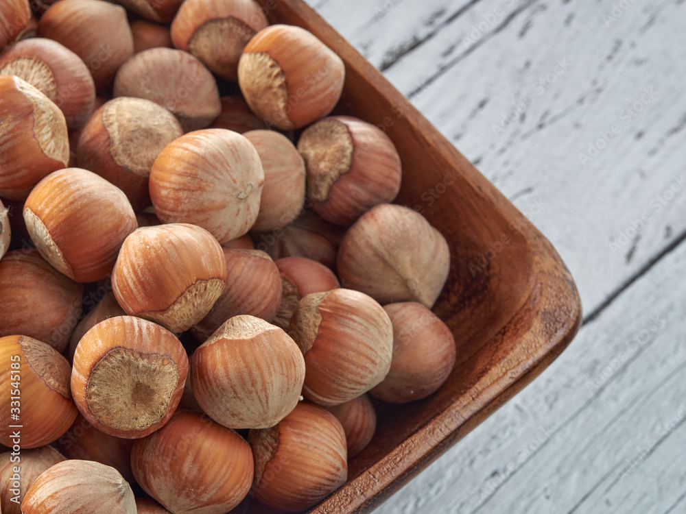 Hazelnuts lie on light wooden boards.Useful hazelnut for health.