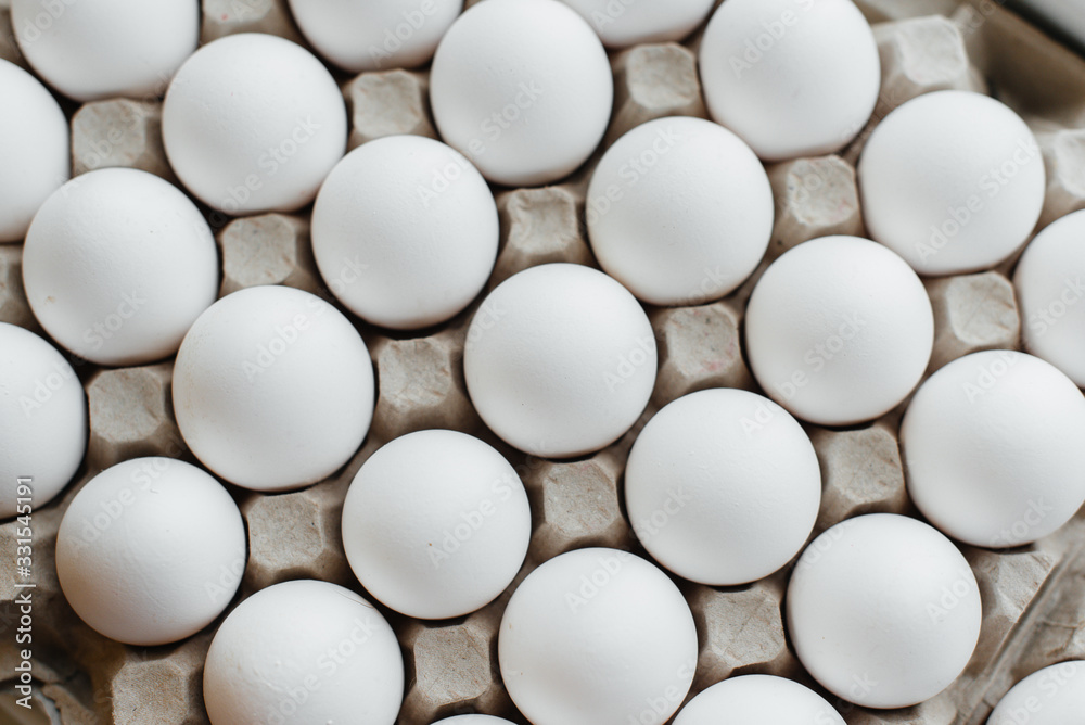 Tray of white fresh eggs close-up on a cardboard form. Agricultural industry Tray of white fresh eggs close-up on a cardboard form. Agricultural industry