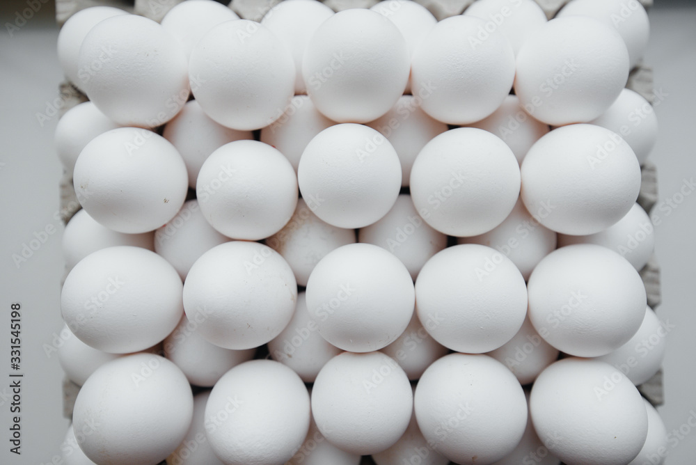 Tray of white fresh eggs close-up on a cardboard form. Agricultural industry Tray of white fresh eggs close-up on a cardboard form. Agricultural industry