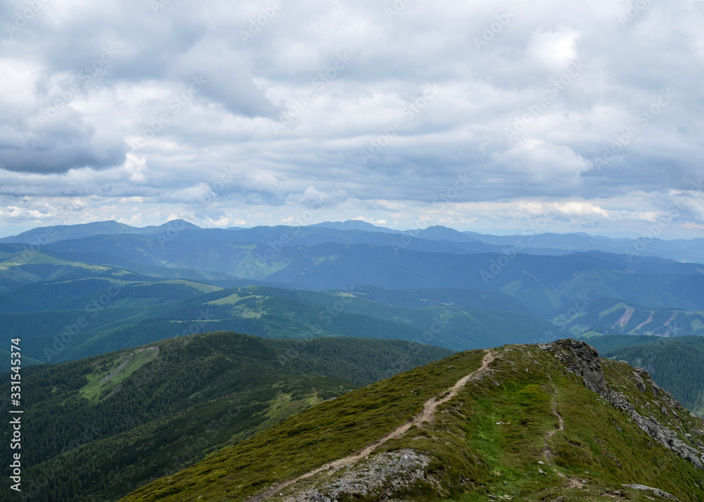 Beautiful view of the mountain range Chornohora with its spurs in the Carpathian Mountains with cloudy sky in summer, Ukraine 