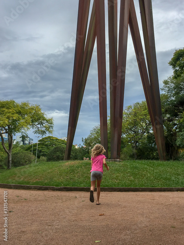 blond girl running on a park at a cloudy day  photo