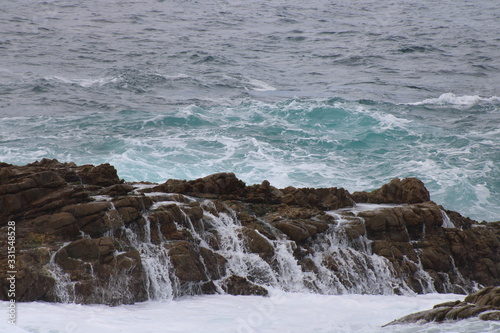 waves pouring down rock