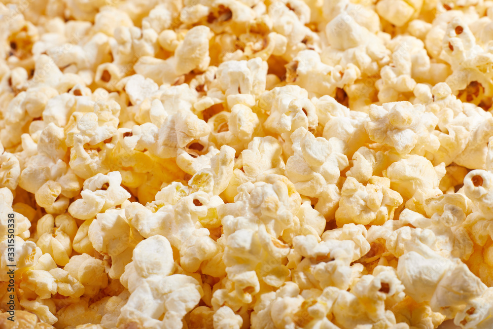 Flatlay of salted popcorn with cheese. Heap of homemade delicious popcorn on a rustic wooden table. Snacks and food for a movie theater or cinema. Fastfood background.  Strip texture