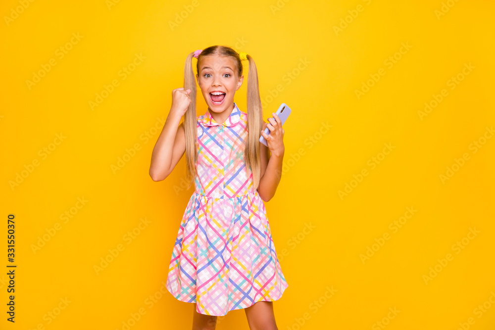 Photo of beautiful crazy little lady hold telephone popular blogger celebrating first repost many likes followers wear checkered sun dress isolated bright yellow color background Photo of beautiful crazy little lady hold telephone popular blogger celebrating first repost many likes followers wear checkered sun dress isolated bright yellow color background