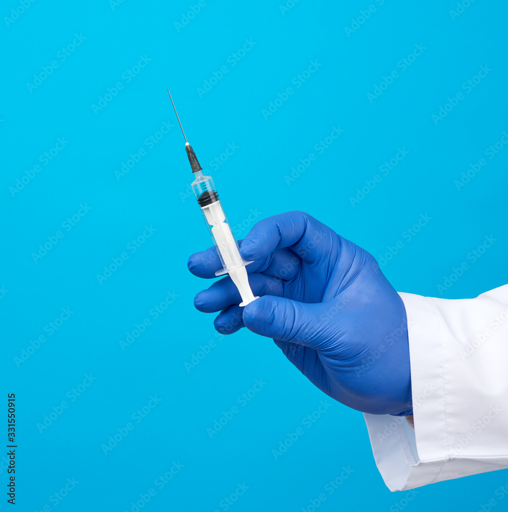 male doctor in a white coat holds a plastic syringe with a needle male doctor in a white coat holds a plastic syringe with a needle