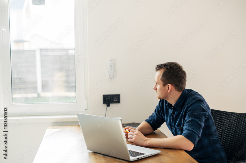 Young man working from home using laptop. Young man working from home using laptop.