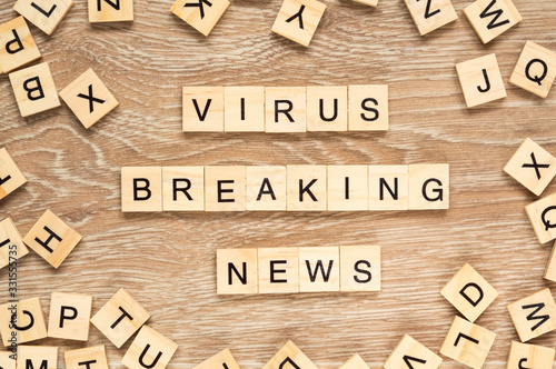 The words "Virus Breaking News" spelt out with letter tiles on the wooden background