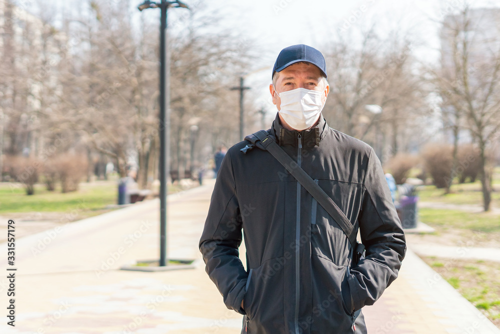 Portrait of a man in a medical protective mask on his face, Covid-19 coronavirus pandemic, virus protection Portrait of a man in a medical protective mask on his face, Covid-19 coronavirus pandemic, virus protection