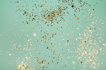 Golden flying sparkles on blue holiday background. Festive backdrop for your projects.