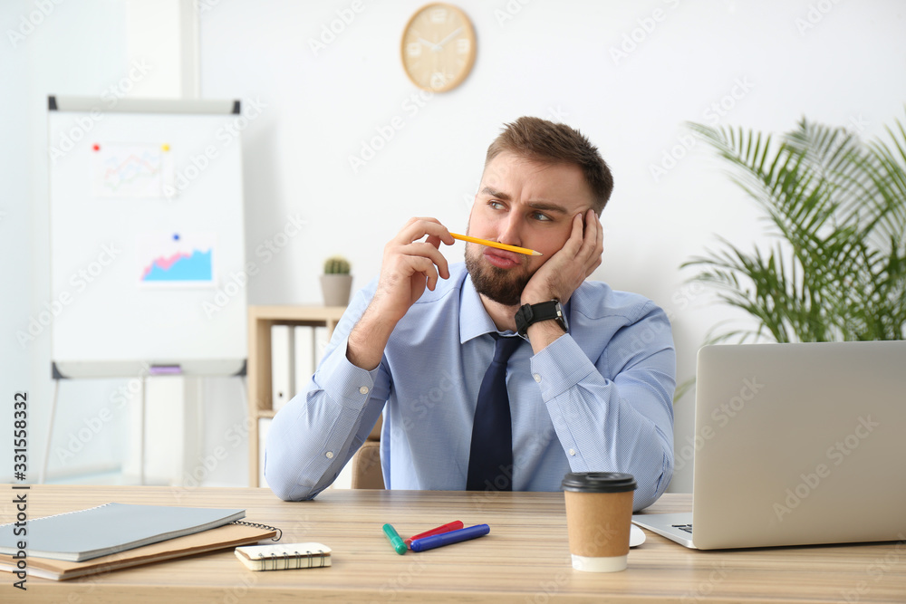Lazy young office employee procrastinating at workplace Lazy young office employee procrastinating at workplace