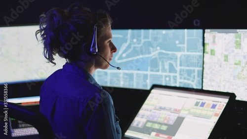 Emergency dispatcher focuses on her computer screens while hard at work