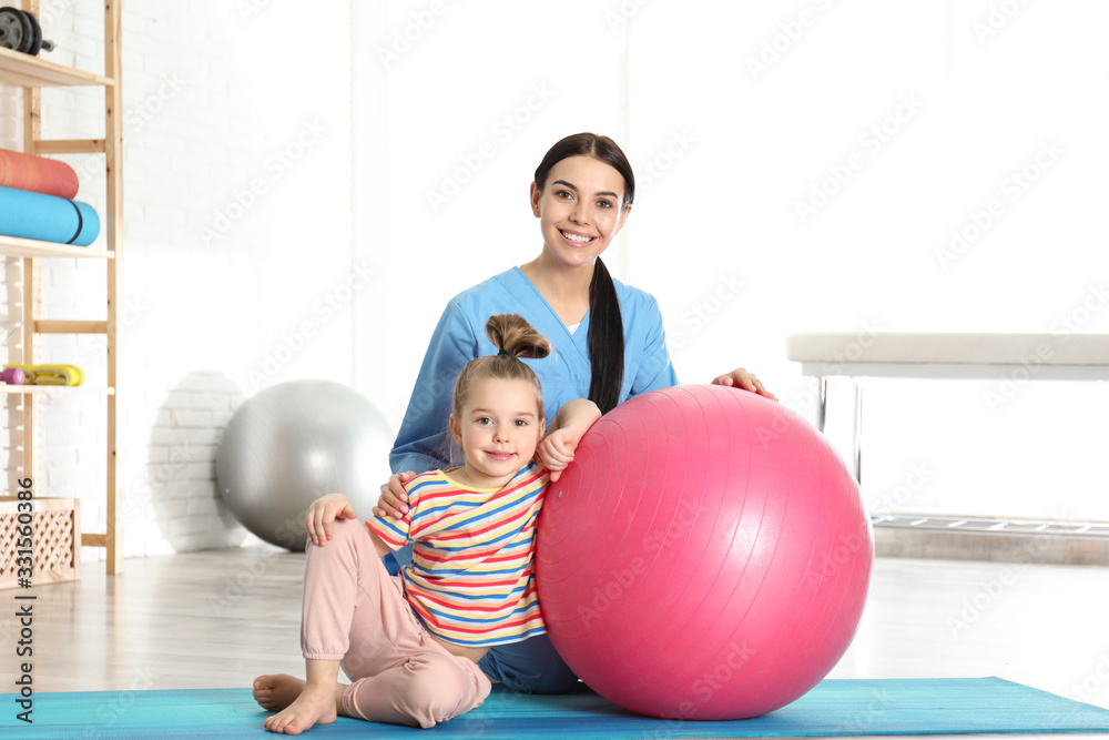 Orthopedist working with little girl in hospital gym Orthopedist working with little girl in hospital gym