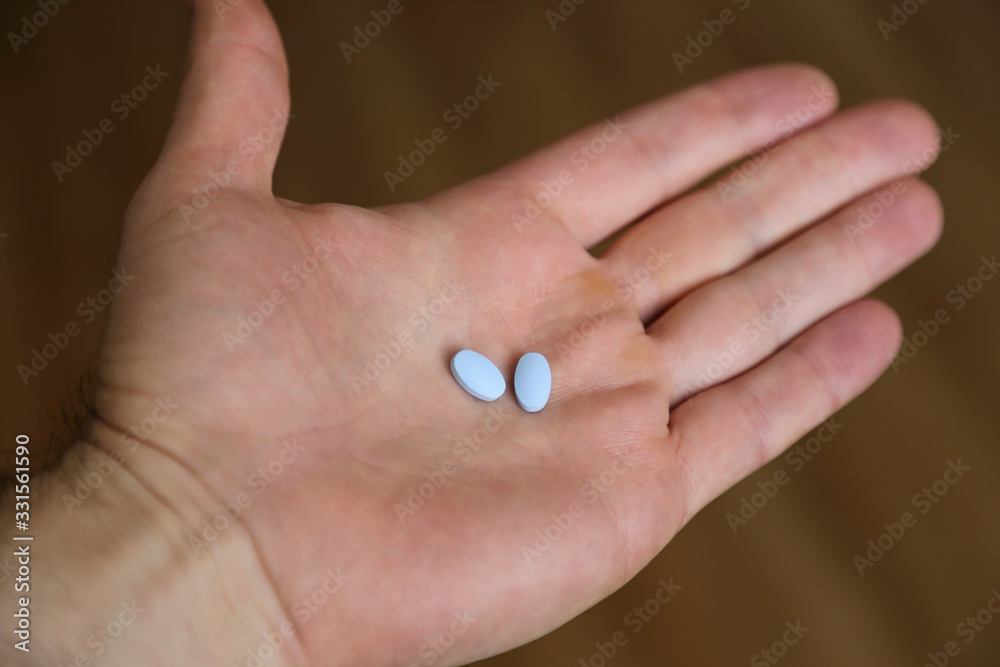 Two generic naproxen sodium pills, used as a nonsteroidal anti-inflammatory painkiller drug (NSAID), are shown held in a hand. Two generic naproxen sodium pills, used as a nonsteroidal anti-inflammatory painkiller drug (NSAID), are shown held in a hand.