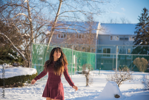 Woman having fun and enjoying snow after snowstorm on sunny day