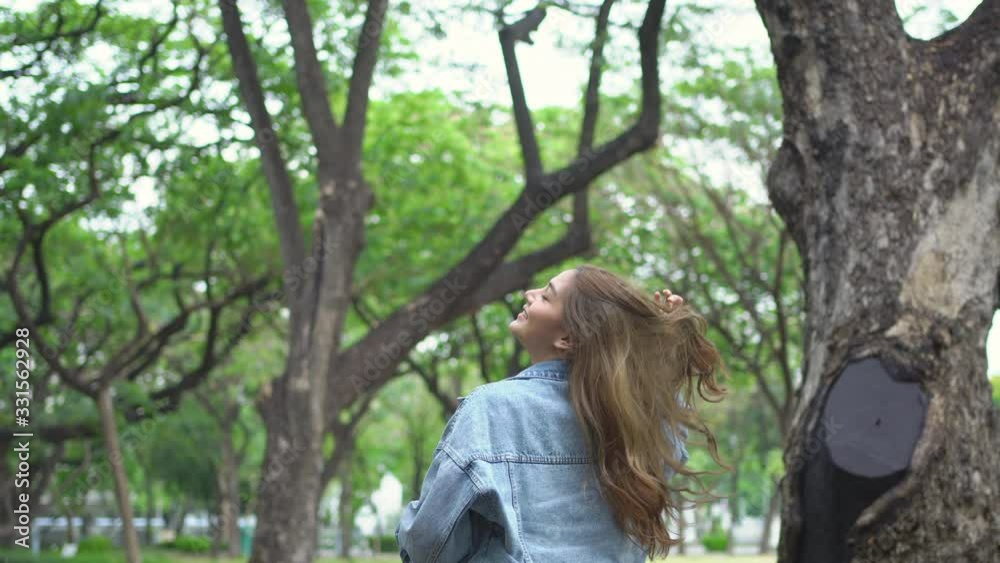 4K Low angle view of Young beautiful Asian woman with long hair and smiling face looking up at the tree in summertime. Confidence teenage girl having fun and enjoying in beautiful nature and lifestyle 4K Low angle view of Young beautiful Asian woman with long hair and smiling face looking up at the tree in summertime. Confidence teenage girl having fun and enjoying in beautiful nature and lifestyle