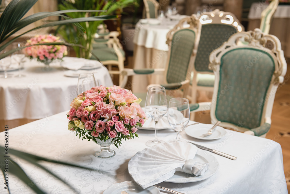 Colorful wedding bouquet on a restaurant served table. Bridal bouquet. Luxury royal restaurant. Valentine's day, birthday, dating or mother's day decoration Colorful wedding bouquet on a restaurant served table. Bridal bouquet. Luxury royal restaurant. Valentine's day, birthday, dating or mother's day decoration